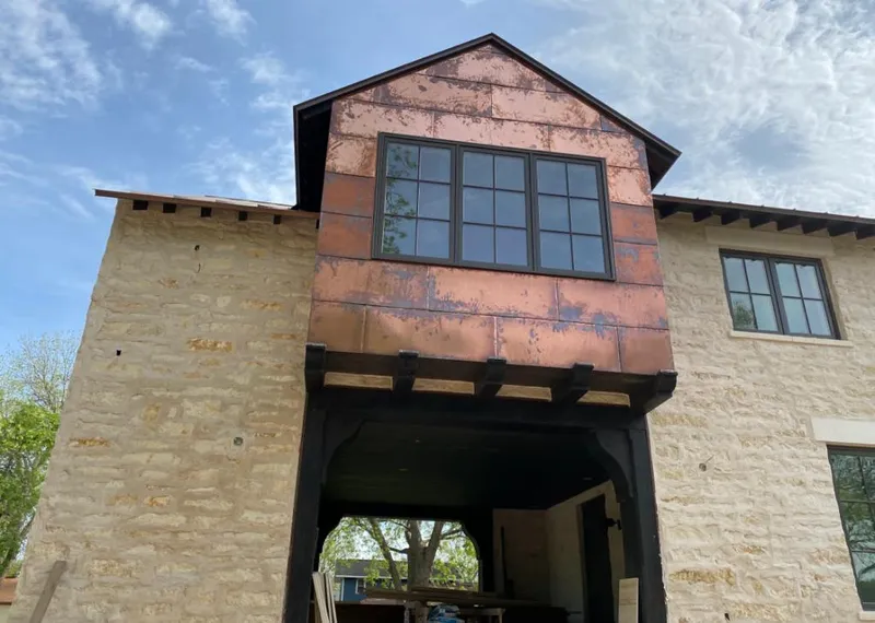 Copper metal panel facade on a stone building for Skylight Installation in Grass Lake